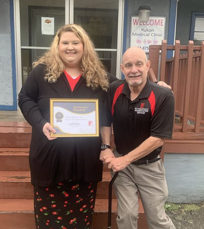 DRS presents framed certificate to Yukon Medical Clinic representative